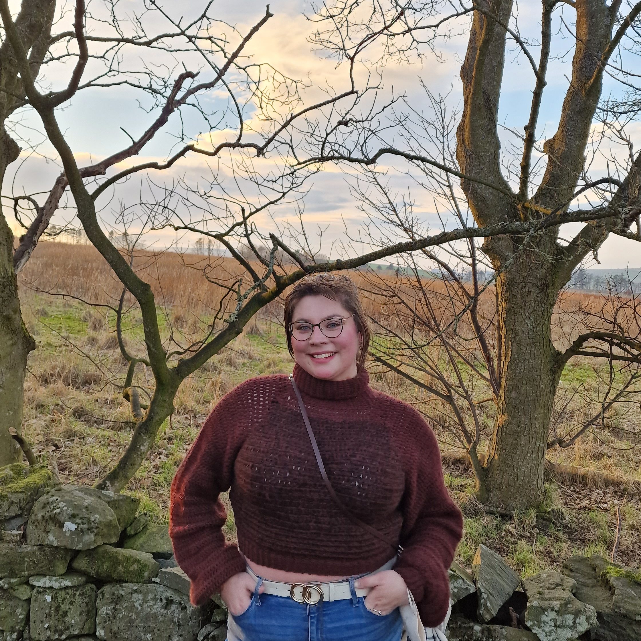 Michelle posing in a funnel neck jumper she crocheted. 