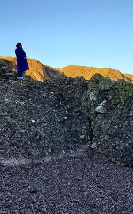 Michelle standing on a cliff looking into the distance. 